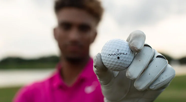 man holding golf ball up to camera