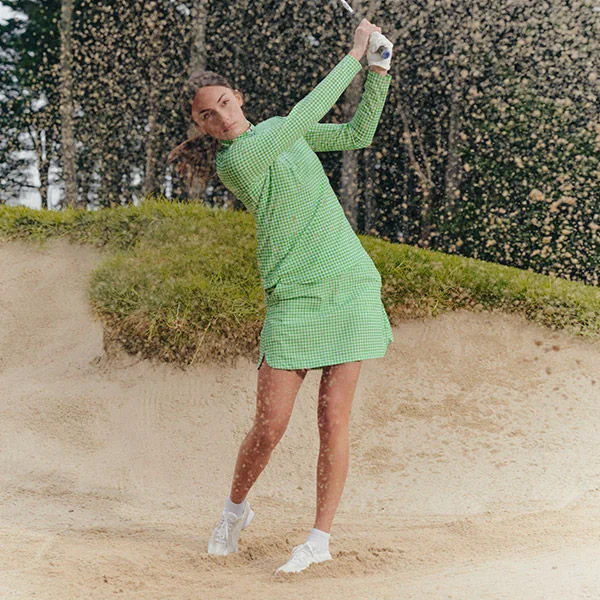 A woman carrying a golf club.